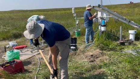 researchers in a field using equipment 
